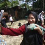 Pengunjung berinteraksi dengan hewan di kawasan Faunaland Ancol.