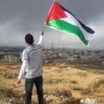 Seseorag mengibarkan Bendera Palestina (dok:Unsplash/Ahmed Abu Hameeda)