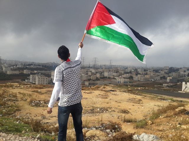 Seseorag mengibarkan Bendera Palestina (dok:Unsplash/Ahmed Abu Hameeda)