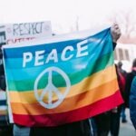 Seseorang Mengibarkan Spanduk Perdamaian (dok:Unsplash/Alice Donovan)
