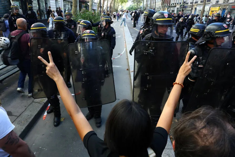 Polisi antihuru-hara berhadapan dengan siswa SMA saat unjuk rasa di Paris [Yves Herman/Reuters]