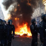 Petugas kepolisian berjaga saat api berkobar di Paris pada Minggu malam. Foto: Abdul Saboor/Reuters