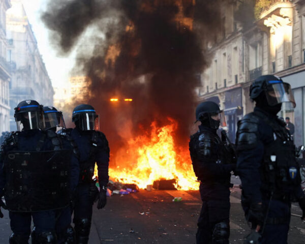 Petugas kepolisian berjaga saat api berkobar di Paris pada Minggu malam. Foto: Abdul Saboor/Reuters