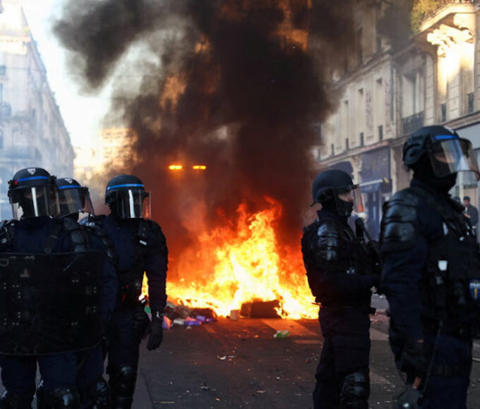 Petugas kepolisian berjaga saat api berkobar di Paris pada Minggu malam. Foto: Abdul Saboor/Reuters